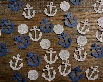 Puede incluir: Una colección de confeti de ancla de color azul marino y plateado. Las anclas están recortadas en papel y tienen un acabado brillante. El confeti es perfecto para una fiesta con temática náutica.