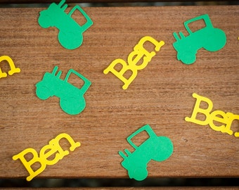 May include: Green tractor cutouts and yellow paper cutouts of the name Ben on a wooden surface.