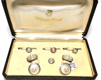 May include: A set of six pearl cufflinks and studs in a black leather box with a white satin lining. The box is labeled "Mikimoto Pearls".