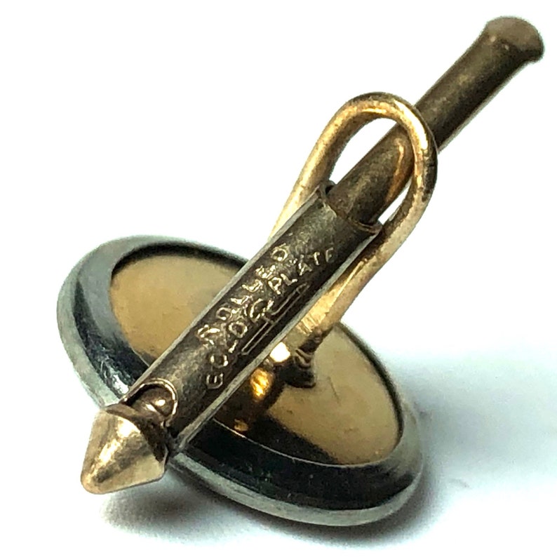 Puede incluir: Gemelos chapados en oro con un dise&ntilde;o redondo, negro y dorado. La parte posterior del gemelo tiene el texto "Gold Filled 1/20 12K Plate".