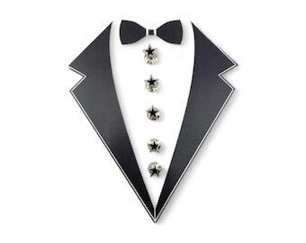 May include: A black tuxedo cutout with five silver star-shaped buttons with black centers.