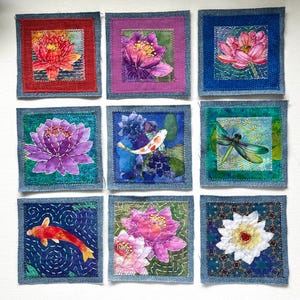 May include: A set of nine square fabric patches arranged in a grid, featuring embroidered and printed designs of lotus flowers, koi fish, and a dragonfly. Each square is framed with a denim border and detailed with visible stitching.