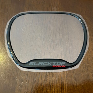 May include: Black plastic emblem with the text "BLACKTOP EDITION" in white and red lettering.
