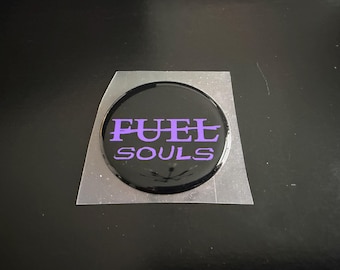 Emblema de la tapa del depósito de combustible del Challenger en color púrpura.