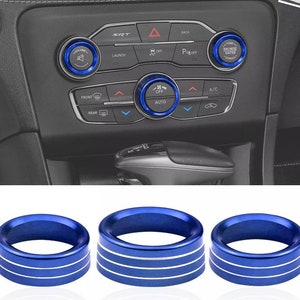 May include: Three blue and white car knob trim rings. The rings have a blue outer ring with a white inner ring and three white stripes.