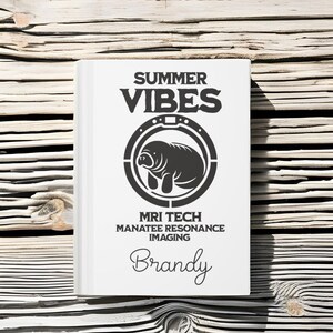 May include: A white book with the text "SUMMER VIBES" in black letters. A black and white illustration of a manatee inside a circle with the text "MRI TECH MANATEE RESONANCE IMAGING" and the name "Brandy" written in cursive.
