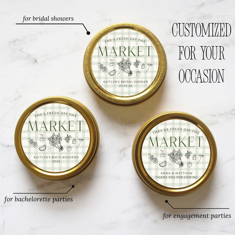 May include: Three gold-rimmed tins with green and white checkered tops. The text "SHE'S FRESH OFF THE MARKET" and "THEY'RE FRESH OFF THE MARKET" is printed on the lids, along with event details and illustrations of fruit.