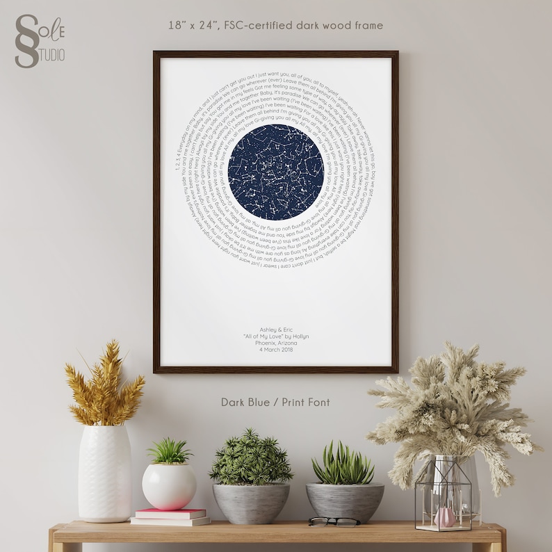 May include: A dark blue and white star map print with a circle of lyrics from the song "All of My Love" by Hollyn. The print is framed in a dark wood frame and measures 18 inches by 24 inches. The text below the star map reads "Ashley & Eric, "All of My Love" by Hollyn, Phoenix, Arizona, 4 March 2018".