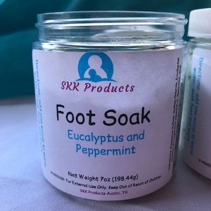 Puede incluir: Un tarro de plástico blanco con una etiqueta azul y blanca que dice "SKK Products Foot Soak Eucalyptus and Peppermint Net Weight 7oz (198.44g) WARNING: For External Use Only. Keep Out of Reach of Children SKK Products Austin, TX".