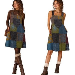May include: A sleeveless knee-length pinafore dress featuring a patchwork design with various textured fabric squares in shades of blue, green, brown, and black. The dress includes a front chest pocket and intricate blue floral embroidery.