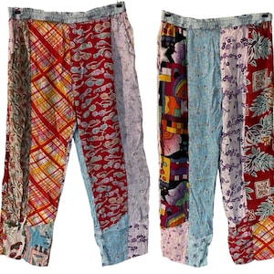 May include: Patchwork pants with a variety of patterns and colors. The pants feature a mix of fabrics, including red with sunglasses, floral prints, and geometric designs. The elastic waistband is light blue.