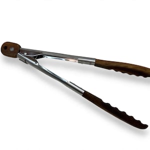 May include: A pair of kitchen tongs featuring a polished silver-colored metal frame and dark brown wooden handles. The handles have a scalloped, ergonomic grip design, and the metal hinge at the top includes a circular hole for hanging storage.