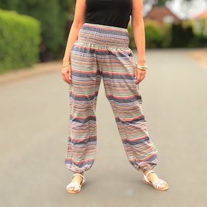 May include: A pair of striped pants with a wide, elastic waistband. The pants are made of a soft, flowing fabric and have a relaxed fit. The pants are a mix of blue, pink, and white stripes.