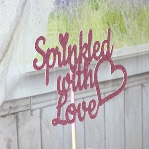May include: Pink glitter cake topper with the text "Sprinkled with Love" and a heart.