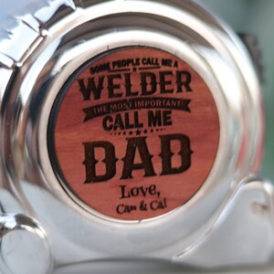 May include: A silver tape measure with a wooden insert that reads "Some people call me a welder, the most important call me Dad. Love, Cap & Cal."