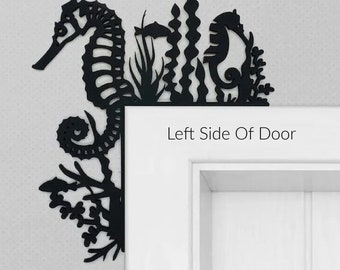 May include: Black metal wall decor featuring a seahorse, seaweed, and coral. The decor is mounted on the left side of a white door. The text "Left Side Of Door" is visible below the decor.