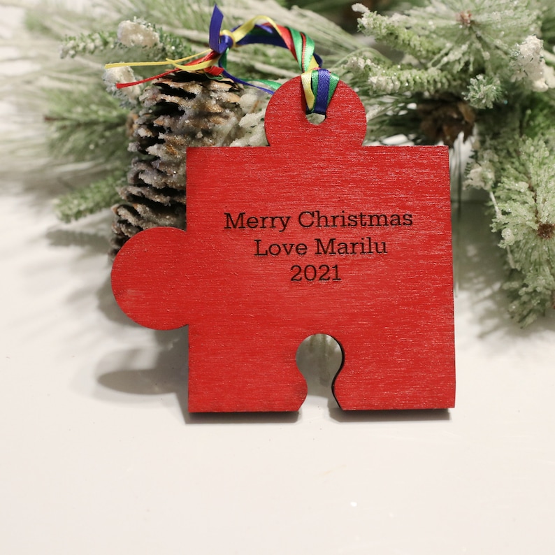 May include: Red wooden jigsaw piece Christmas ornament with the text "Merry Christmas Love MariLu 2021"