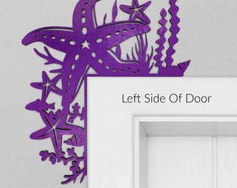 May include: Purple wooden cutout of a starfish and sea life, mounted on the left side of a white door. The text "Left Side Of Door" is visible below the cutout.