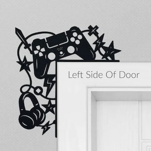 May include: Black metal wall decor featuring a video game controller, headphones, and lightning bolts. The decor is mounted on the left side of a door. The text "Left Side Of Door" is visible below the decor.