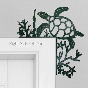 May include: A green metal sea turtle doorstop with a cutout design. The turtle is positioned on a white door frame with the text "Right Side Of Door" below it. The turtle is surrounded by sea life, including seaweed, starfish, and coral.