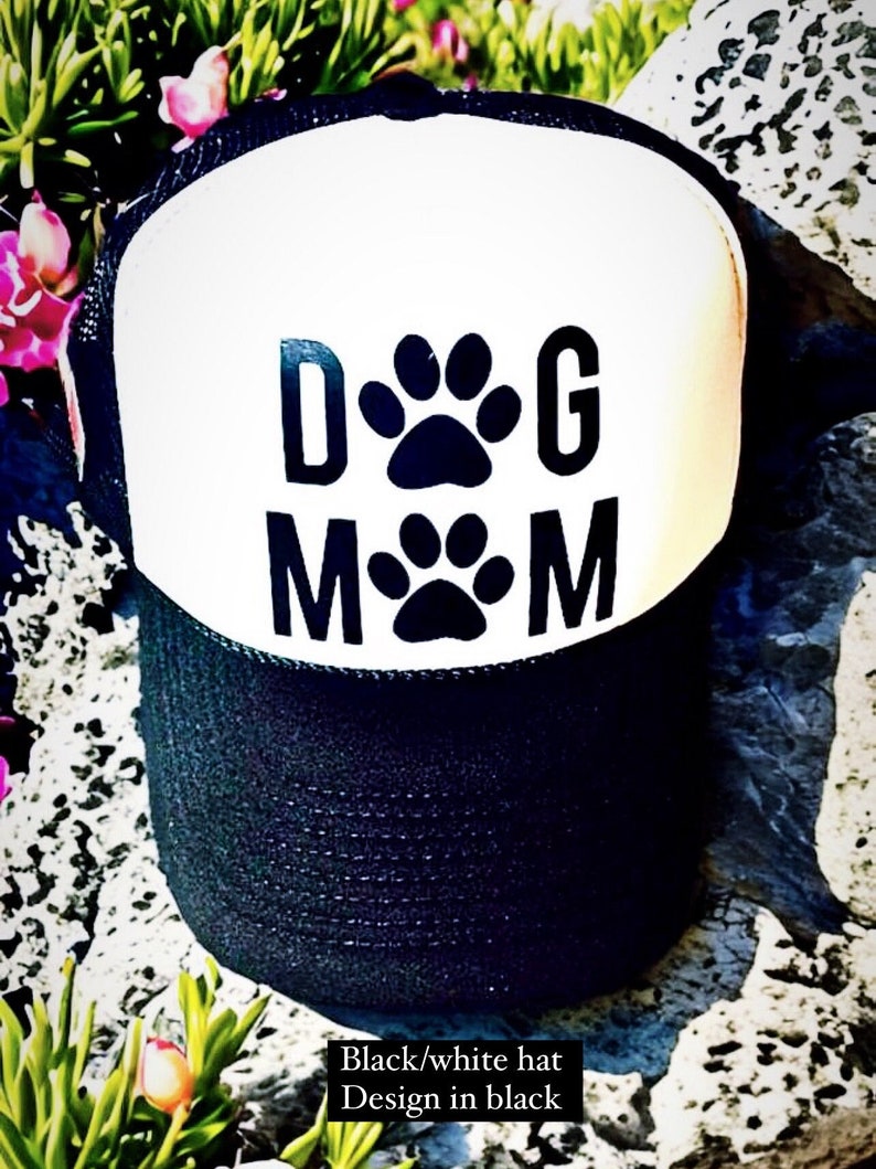 May include: Black and white trucker hat with a black paw print design that says "Dog Mom".
