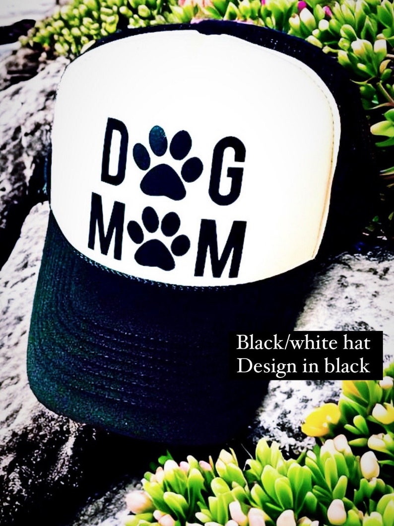May include: Black and white trucker hat with a black paw print design that says "Dog Mom".