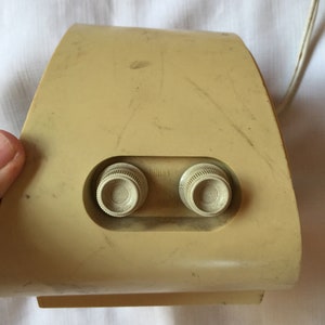 May include: A beige vintage radio with two round knobs labeled "Tuning" and "Volume".