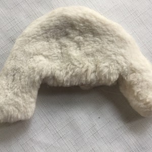 May include: A white faux fur earflap hat with a soft, fluffy texture.