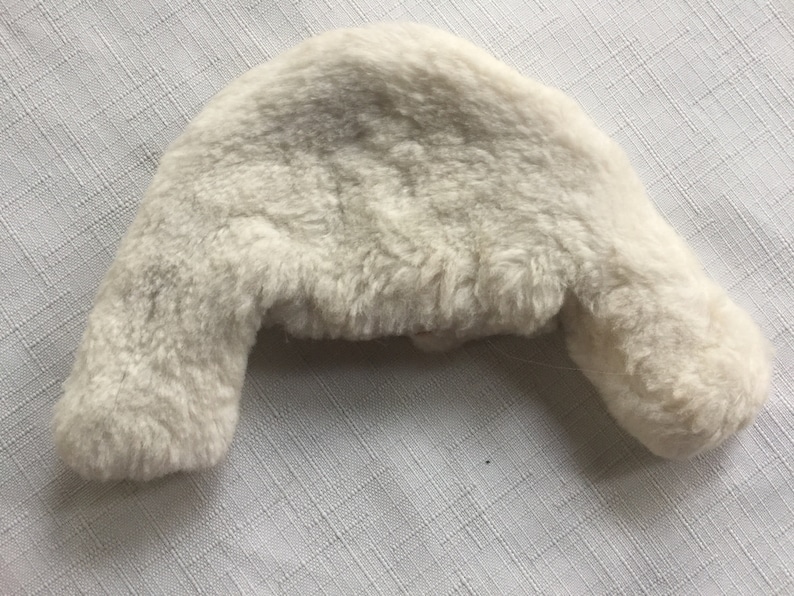 May include: A white faux fur earflap hat with a soft, fluffy texture.