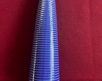 May include: A tall, blue ceramic vase with a ribbed design. The vase is cone-shaped and has a glossy finish.