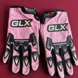 Puede incluir: Par de guantes de moto GLX rosas. Los guantes tienen detalles en negro y el logotipo GLX en blanco. Los guantes tienen una textura de malla y el texto "A-02" es visible.