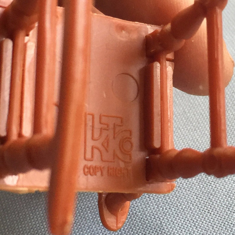K&ouml;nnte beinhalten: Nahaufnahme der Unterseite eines braunen Plastikstuhls mit einem Copyright-Symbol und dem Text "COPY RIGHT".