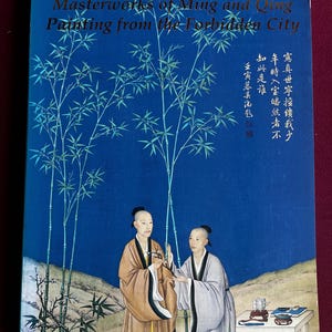 Peut inclure: Livre intitulé "Chefs-d'œuvre de la peinture Ming et Qing de la Cité Interdite". La couverture bleue présente une illustration de deux personnages en tenue traditionnelle, des tiges de bambou et du texte chinois.