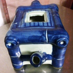 Peut inclure: Br&ucirc;le-encens en c&eacute;ramique bleu et blanc de forme rectangulaire avec une petite ouverture sur le dessus. Le br&ucirc;leur est d&eacute;cor&eacute; de motifs de tiges de bambou et d'un bec verseur sur le dessous.