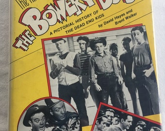 Puede incluir: Una cubierta de libro amarilla con el título "The Films of The Bowery Boys" y una historia ilustrada de The Dead End Kids por David Hayes y Brent Walker. La cubierta presenta fotos en blanco y negro de los actores.