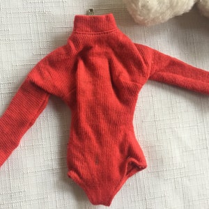 May include: A red long-sleeved turtleneck bodysuit with a ribbed texture.