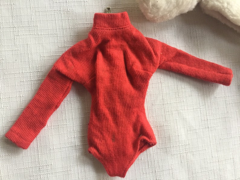 May include: A red long-sleeved turtleneck bodysuit with a ribbed texture.