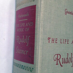 May include: A book titled "The Life and Work of Rudolf Steiner" by Guenther Wachsmuth. The book cover is beige with red text and a red spine.