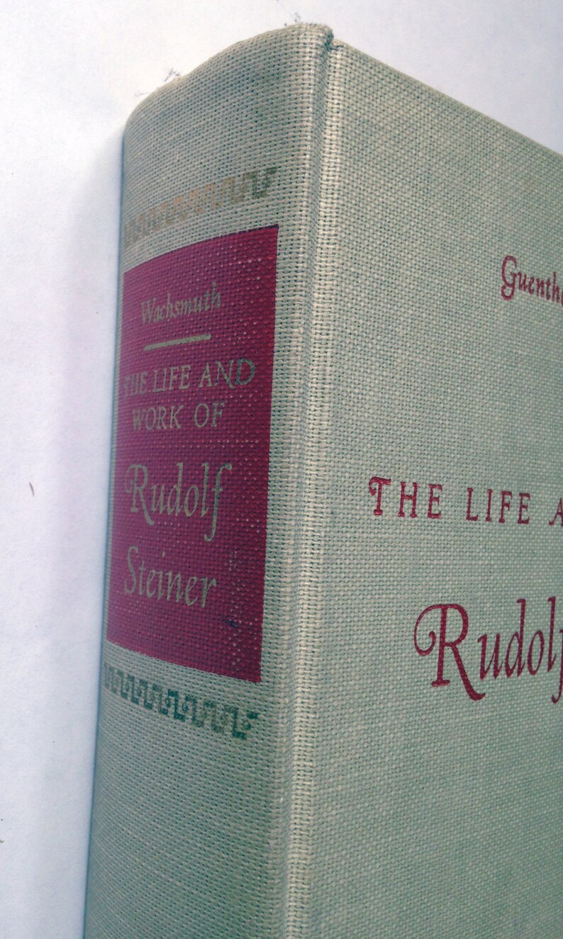 May include: A book titled "The Life and Work of Rudolf Steiner" by Guenther Wachsmuth. The book cover is beige with red text and a red spine.