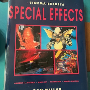 May include: A dark blue book titled Cinema Secrets Special Effects by Dan Millar. The cover features four rectangular images: a creature, a Gremlin, a spaceship in space, and a control panel. Text includes Camera Illusions, Make-up, Animation, Model-making.
