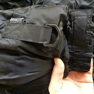 Puede incluir: Pantal&oacute;n negro de nylon con cintura de cord&oacute;n y cierre de gancho y bucle de metal. El pantal&oacute;n tiene una etiqueta que dice "Brooklyn Express".