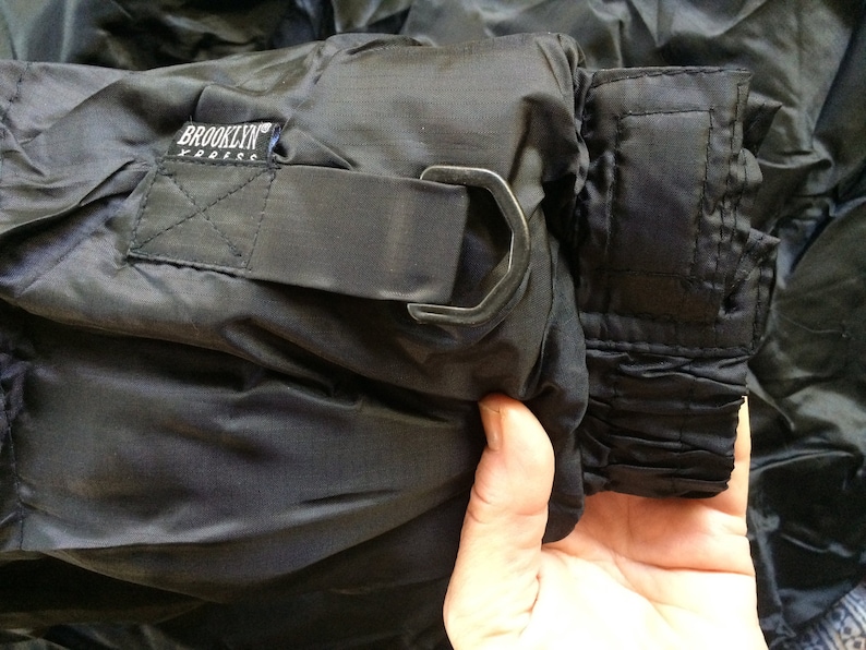 Puede incluir: Pantal&oacute;n negro de nylon con cintura de cord&oacute;n y cierre de gancho y bucle de metal. El pantal&oacute;n tiene una etiqueta que dice "Brooklyn Express".