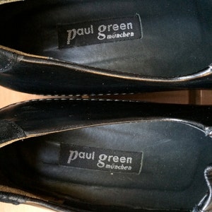 Puede incluir: Primer plano del interior de un zapato de cuero negro con una etiqueta negra que dice "Paul Green M&uuml;nchen".