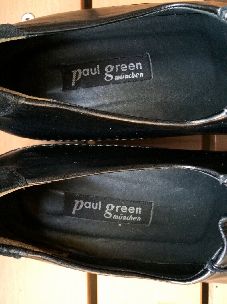 Puede incluir: Primer plano del interior de un zapato de cuero negro con una etiqueta negra que dice "Paul Green M&uuml;nchen".