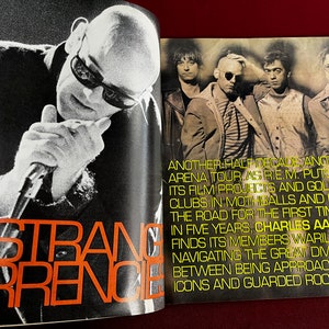 May include: A black and white photo of a band, R.E.M., with the text "Another half decade, another arena tour as R.E.M. puts its film projects and golf clubs in mothballs and hits the road for the first time in five years, Charles Aaron finds its members warily navigating the great divide between being approachable icons and guarded rock stars."