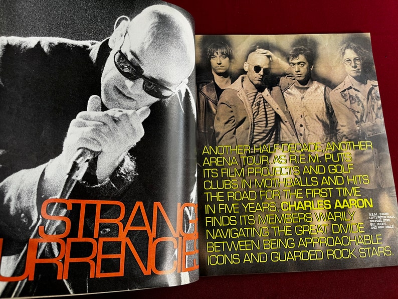 May include: A black and white photo of a band, R.E.M., with the text "Another half decade, another arena tour as R.E.M. puts its film projects and golf clubs in mothballs and hits the road for the first time in five years, Charles Aaron finds its members warily navigating the great divide between being approachable icons and guarded rock stars."