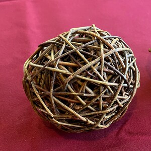 May include: A brown woven sphere made of thin twigs, creating a decorative and natural-looking object.
