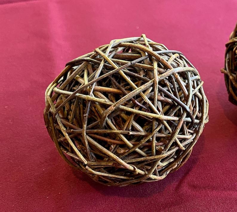 May include: A brown woven sphere made of thin twigs, creating a decorative and natural-looking object.