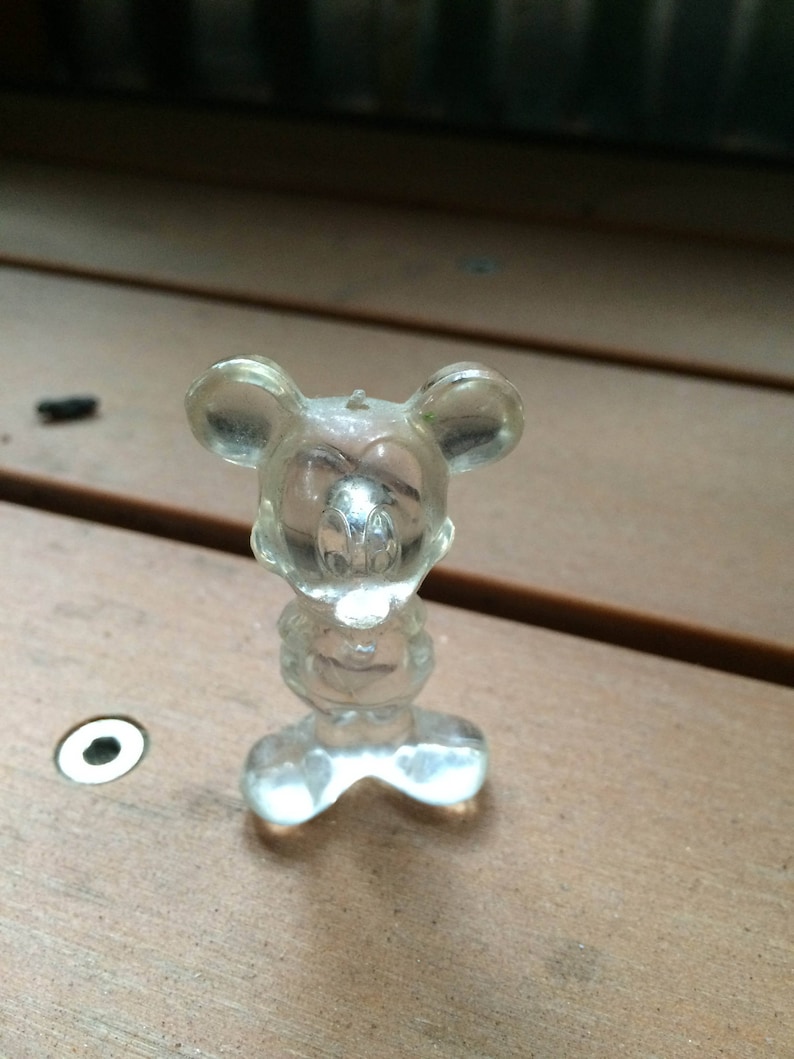 Puede incluir: Una figurita de pl&aacute;stico transparente de Mickey Mouse. La figurita est&aacute; de pie con los brazos a los lados. La figurita mide aproximadamente 7,5 cm de alto.