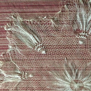 May include: White crocheted lace doily with a delicate floral pattern. The lace is made of fine threads and has a delicate, airy feel.
